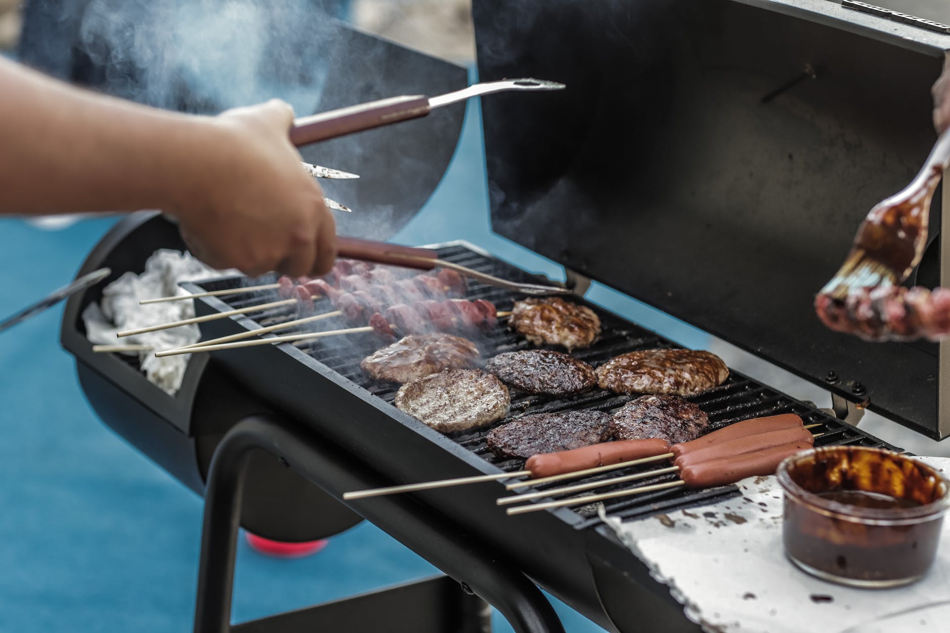 person grilling sausage and meat